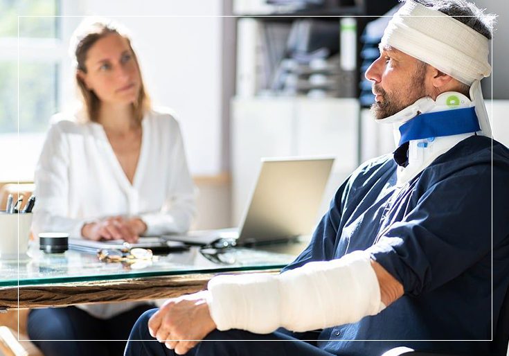 A man with a broken arm and bandaged head sitting in front of a woman.