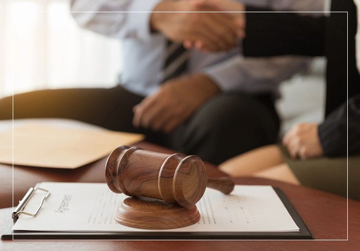 A judge 's gavel sitting on top of papers.