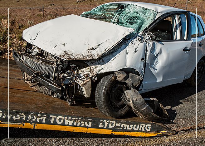 A white car that has been smashed in the road.