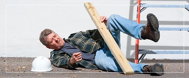 A man laying on the ground holding onto a wooden board.