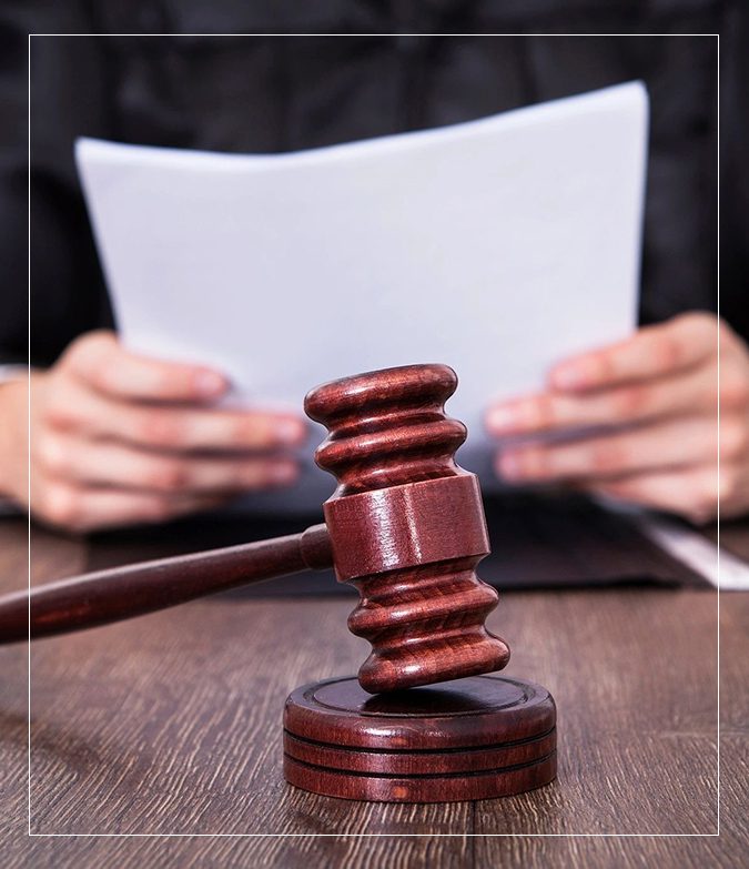 A judge 's gavel sitting on top of a wooden table.