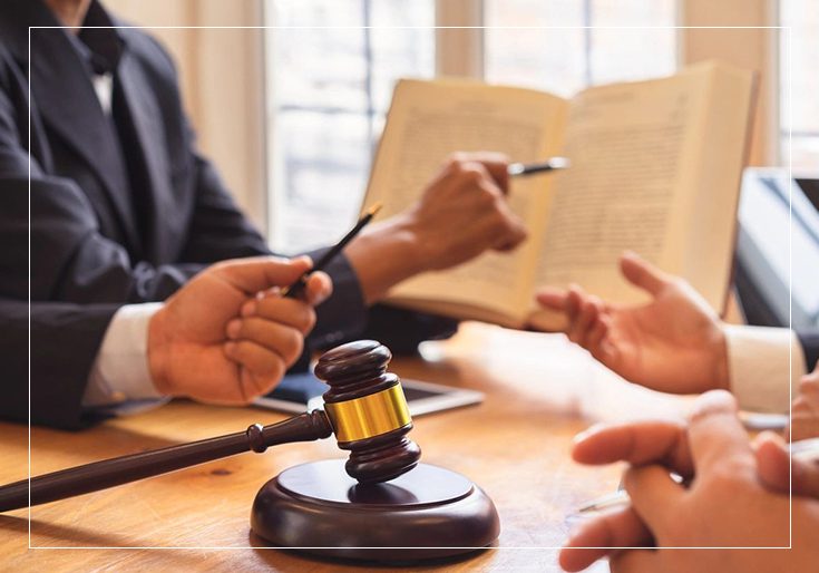 A group of people sitting around a table with papers and a gavel.