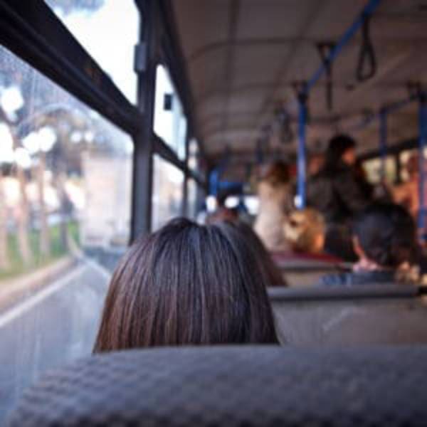 A woman sitting on the bus looking out of window.